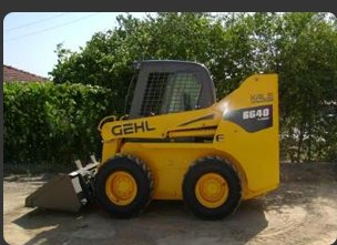 Kova takılı sarı GEHL mini yükleyici, şantiye alanında